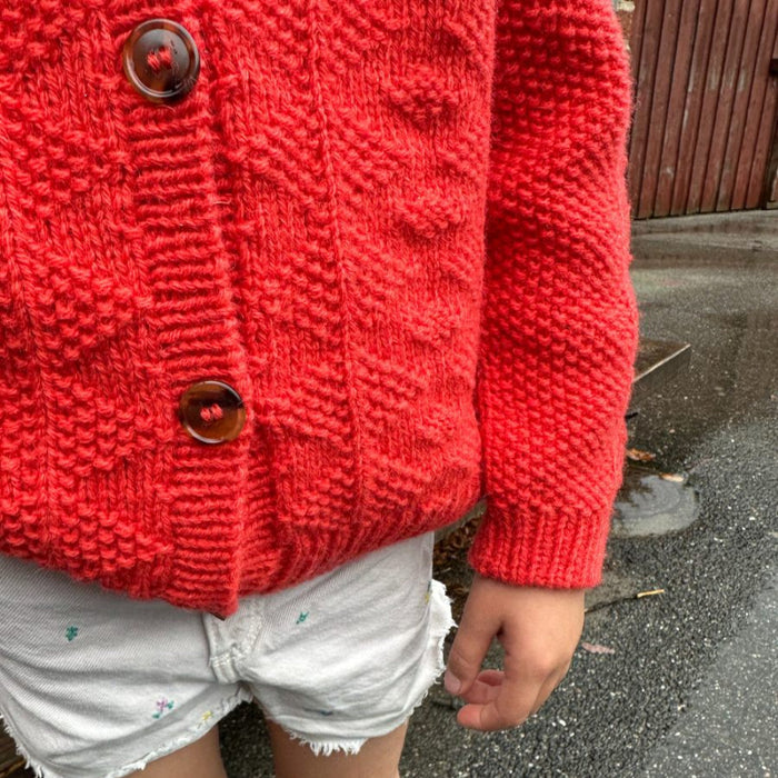Little Esther Jacket Knitting Pattern by PetiteKnit in textured red design with large buttons.