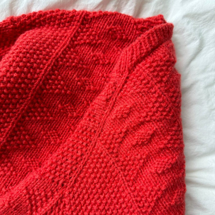 Textured red knitted jacket from PetiteKnit's Little Esther Jacket pattern.