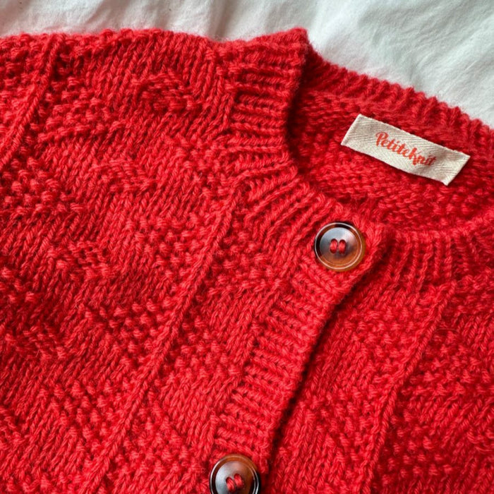 Red textured Little Esther Jacket with buttons, knitted from PetiteKnit pattern.