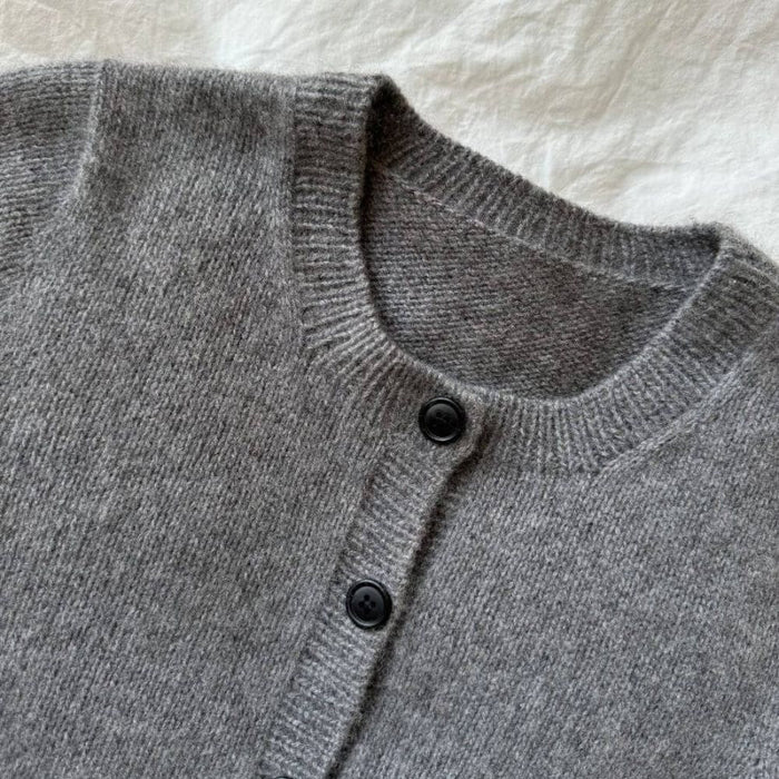 Gray knit cardigan with buttons knitted using PetiteKnit's Maggie Cardigan pattern.