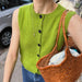 Maggie Vest Knitting Pattern by PetiteKnit in vibrant green with button details and ribbed armhole edges.