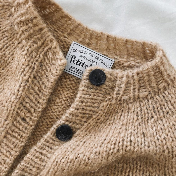 Novice Cardigan Junior Chunky Edition knitting pattern by PetiteKnit, featuring ribbed neck edge and stockinette stitch with button details.
