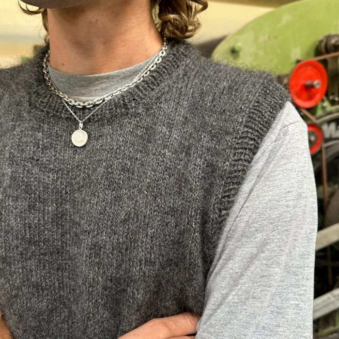 Knitted grey slipover worn by a man over a light grey t-shirt, showcasing the PetiteKnit pattern.