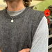Knitted grey slipover worn by a man over a light grey t-shirt, showcasing the PetiteKnit pattern.