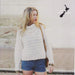 High neck roll collar sweater in white, worn by model, designed for knitting with Crucci 14 Ply Pure Wool.