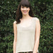 Rolled edge and garter stitch top with a natural finish on a model outdoors; knitting pattern N1462.