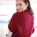 Woman wearing red shrug with textured rib pattern, crafted from Crucci Natural Wonder Artisan yarn.