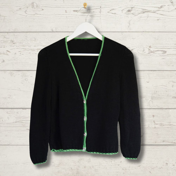 Simple black summer cardigan on hanger with green ribbed edges.