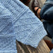 Close-up of the Storm Sweater Baby knit in a textured pattern using PetiteKnit pattern.