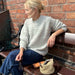 Storm Sweater Knitting Pattern by PetiteKnit, textured design, worn by person seated outdoors.