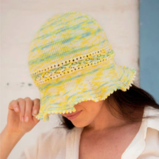 Vega Hat Knitting Pattern with decorative band and ruffled brim in Amano Inti yarn.