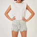 Woman wearing knitted romper set with lace pattern and adjustable waistband, showcasing intermediate-level knitting design.