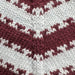 Close-up of a two-color striped knitting pattern in burgundy and light gray, used in the Key Sweater Junior by PetiteKnit.