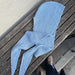 Cozy blue knitted hooded scarf on wooden bench; Sophie Hood knitting pattern.