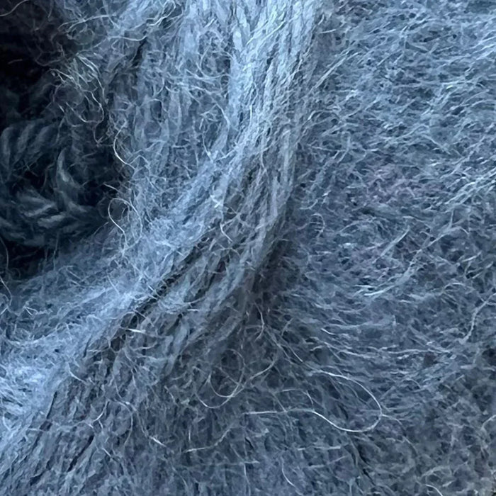 Close-up of soft, textured Chaska Alpaca Air 12-ply yarn in muted blue, ideal for crafting stylish accessories.