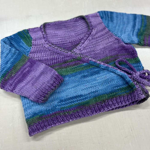 Crossover Jacket & Hat Knit Kit in variegated colors made with organic cotton for babies, featuring ribbed edging and crossover design.