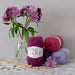 African Expressions LOVE 12Ply Mohair yarn in various colors, displayed with knitting needles and purple flowers, highlighting its luxurious texture and African origin.