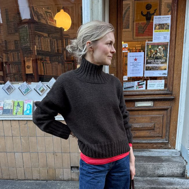 Woman wearing a hand-knitted Hannah Sweater with round neckline and oversized fit in soft stockinette stitch