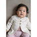 Baby wearing a white cardigan with a lace yoke — Carolyn Cardi, Lisa F BC94.
