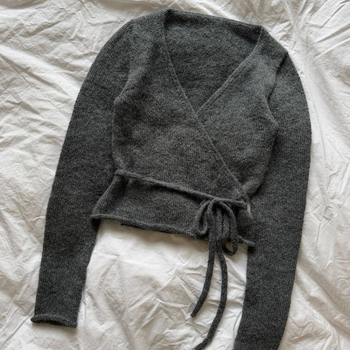 Lucy Wrap Knitting Pattern for a charcoal grey knitted wrap blouse with crossover front and long waist ties