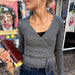 Lucy Wrap Knitting Pattern for a grey knitted wrap blouse with long ties and crossed front
