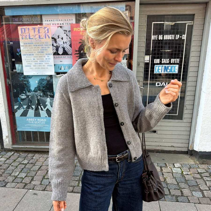 Petra Jacket Knitting Pattern featuring a grey wool jacket with ribbed collar, button front and cropped fit