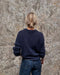 Back view of the navy blue Stockholm Sweater by PetiteKnit worn with jeans, showing the relaxed fit and dropped shoulders